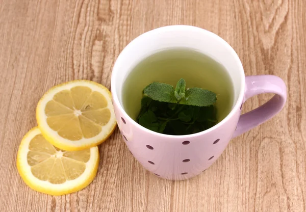 Nane çayı, nane yaprağı ve limon ahşap zemin üzerinde — Stok fotoğraf