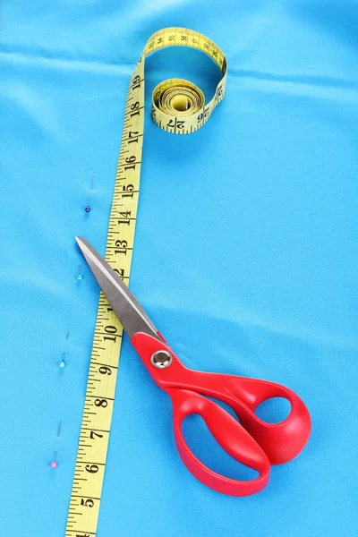 Tesoura e fita métrica em tecido azul — Fotografia de Stock