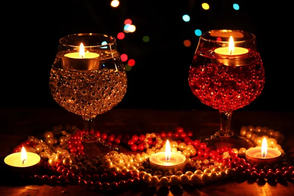 Amazing composition of candles and glasses on wooden table on bright backgr — Stock Photo, Image