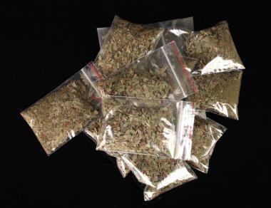 Marihuana in packages on black background clipart