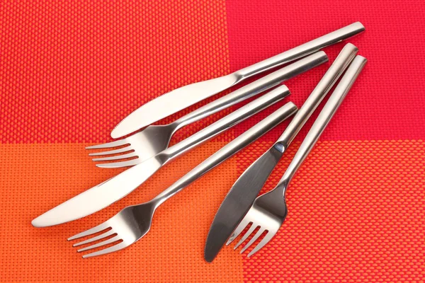 Forks and knives on a red tablecloth — Stock Photo, Image