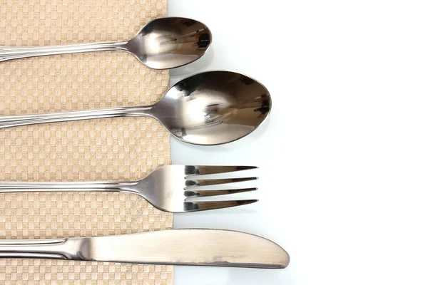 Fork, spoon and knife on a beige tablecloth — Stock Photo, Image