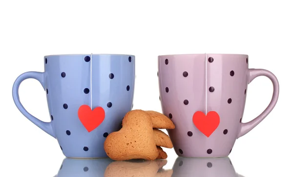 Dos tazas con bolsas de té y galletas aisladas en blanco — Foto de Stock