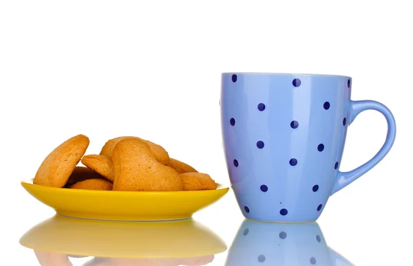 Tazza blu e biscotti a forma di cuore su piastra gialla isolata su bianco — Foto Stock