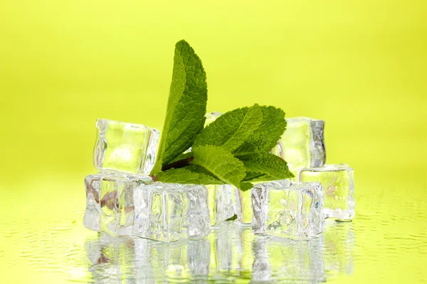 Foglia di menta fresca e cubetti di ghiaccio con goccioline su sfondo verde — Foto Stock