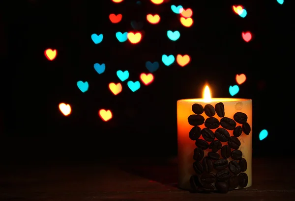 在明亮的背景上的木桌上的咖啡豆与美丽蜡烛 — 图库照片