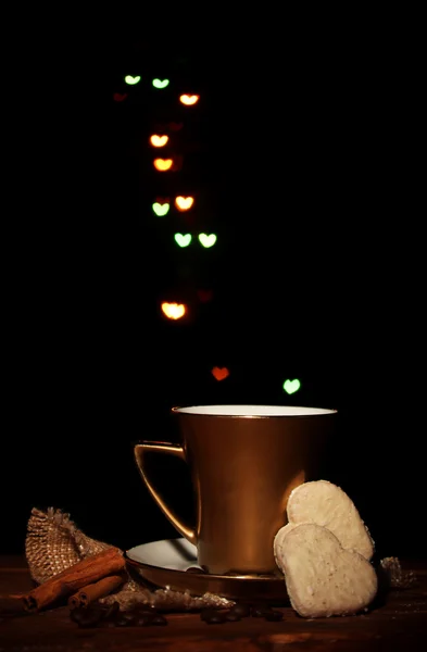 Zlatý šálek kávy na dřevěný stůl na světlé bokeh backdground — Stock fotografie