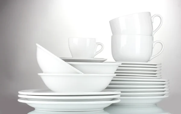 Empty bowls, plates and cups on gray background — Stock Photo, Image