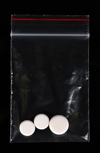 Drogen im Paket auf schwarzem Hintergrund — Stockfoto