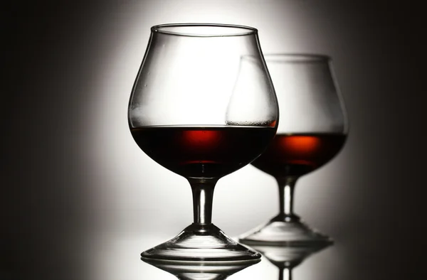 Kaksi lasia konjakkia harmaalla pohjalla — kuvapankkivalokuva