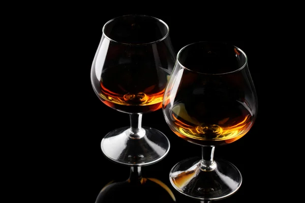 stock image Two glasses of cognac on black background