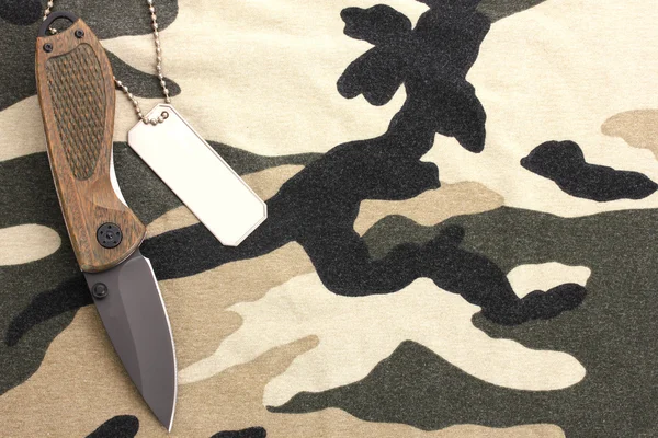 Distintivos do exército e faca no fundo de camuflagem — Fotografia de Stock