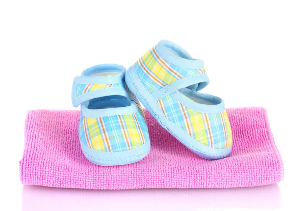 Blaue Babystiefel auf rosa Handtuch isoliert auf weiß — Stockfoto
