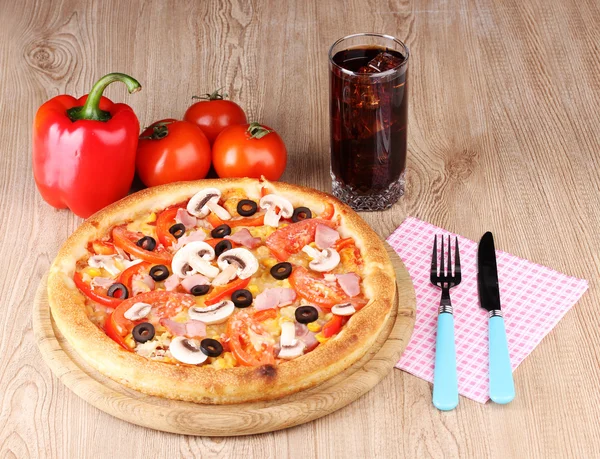 Aromatic pizza and cola on wooden background