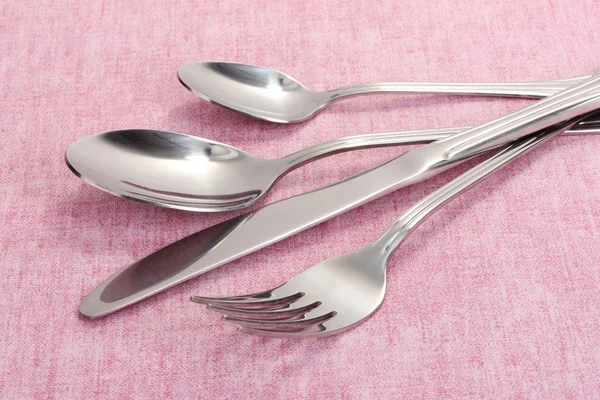 Πιρούνι, κουτάλι και μαχαίρι για ένα ροζ τραπεζομάντιλο — Φωτογραφία Αρχείου