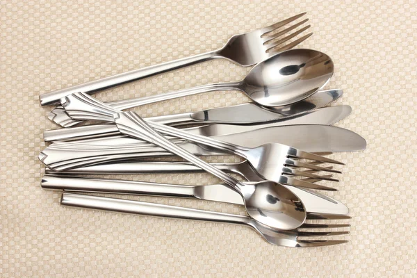 Tenedores, cucharas y cuchillos sobre un mantel beige —  Fotos de Stock