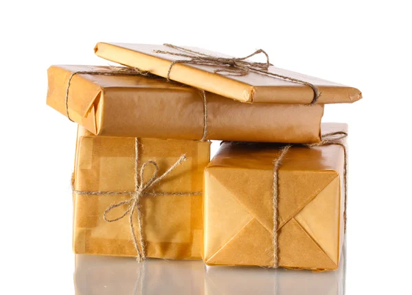 Muchos paquetes envueltos en papel marrón atado con cordel aislado en blanco —  Fotos de Stock