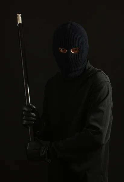 Bandido em máscara preta com tubo isolado em preto — Fotografia de Stock