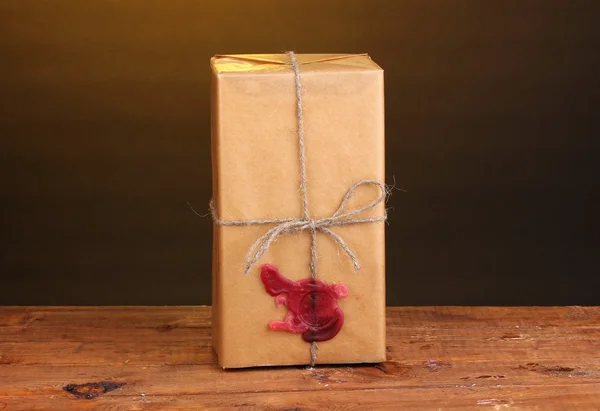 Упаковка с герметичным воском на деревянном столе на коричневом фоне — стоковое фото