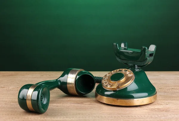 Retro-Telefon auf Holztisch auf grünem Hintergrund — Stockfoto