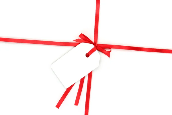 Κενό δώρο ετικέτα με πλώρη για κόκκινο σατέν κορδέλα που απομονώνονται σε λευκό — Φωτογραφία Αρχείου