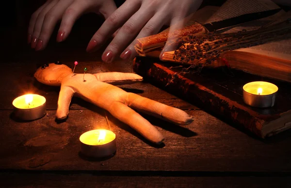 Voodoo panenka kluk na dřevěný stůl ve světle svíček — Stock fotografie