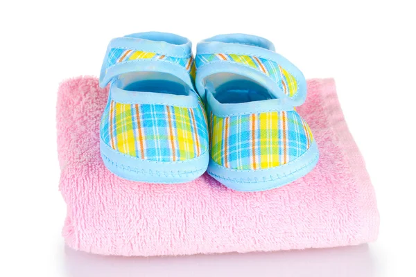 Blaue Babystiefel auf rosa Handtuch isoliert auf weiß — Stockfoto