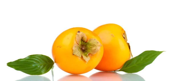 Två aptitretande sharonfrukt med gröna blad isolerad på vit — Stockfoto
