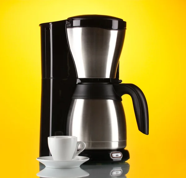 Kaffeemaschine mit weißer Tasse auf gelbem Hintergrund — Stockfoto