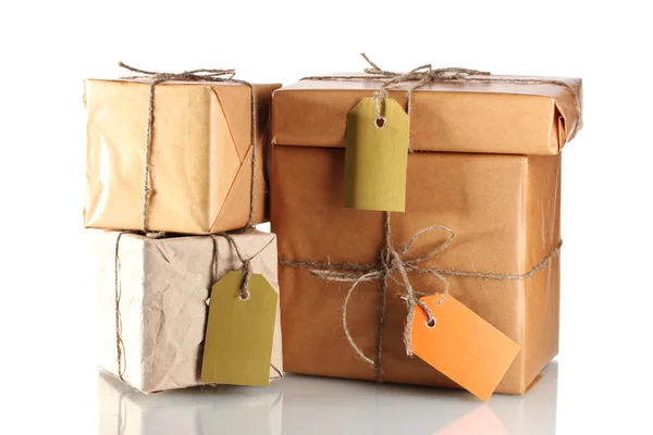 Many parcels wrapped in brown paper tied with twine and with blank labels i — Stock Photo, Image