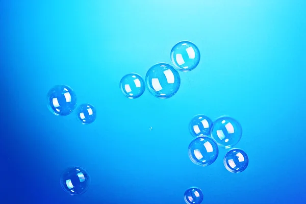 Мыльные пузыри на голубом фоне — стоковое фото