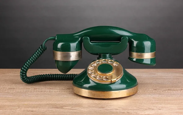 Retro phone on wooden table on grey background — Stock Photo, Image