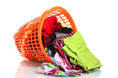 Clothes in orange plastic basket dropped isolated on white clipart