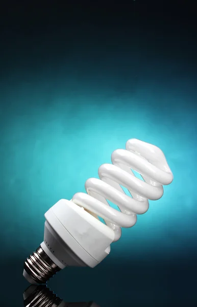 Lampada a risparmio energetico su sfondo blu — Foto Stock