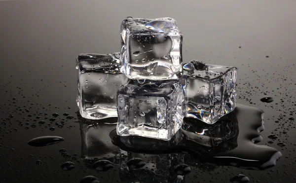 Derretimiento de cubitos de hielo sobre fondo gris — Foto de Stock