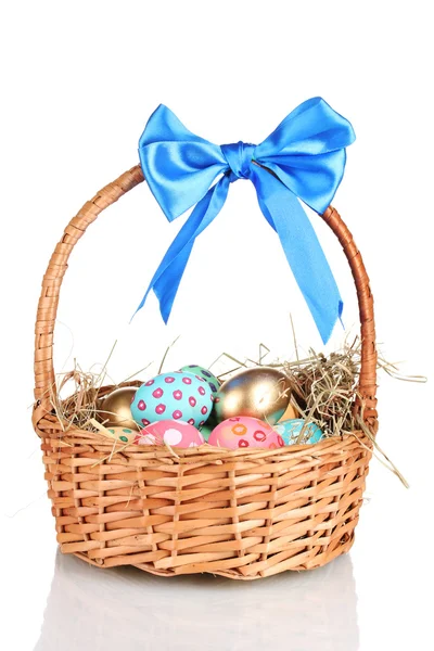 Цветные пасхальные яйца в корзине с голубым луком изолированы на белом — стоковое фото