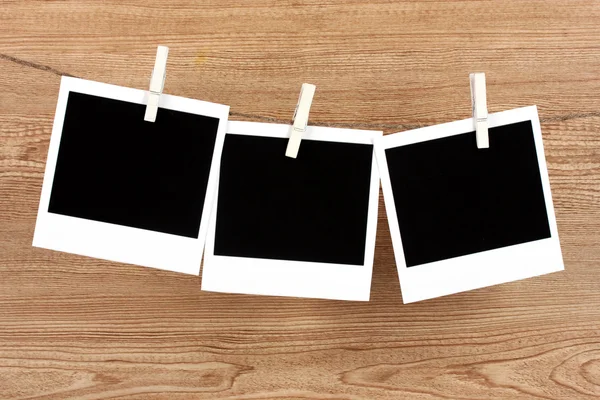 Clothesline üzerinde ahşap arka plan asılı fotoğraf kağıtları — Stok fotoğraf
