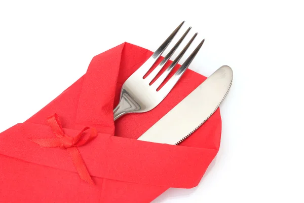Fourchette et couteau dans un tissu rouge avec un arc isolé sur blanc — Photo