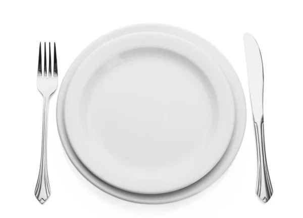 Assiette vide blanche avec fourchette et couteau isolé sur blanc — Photo