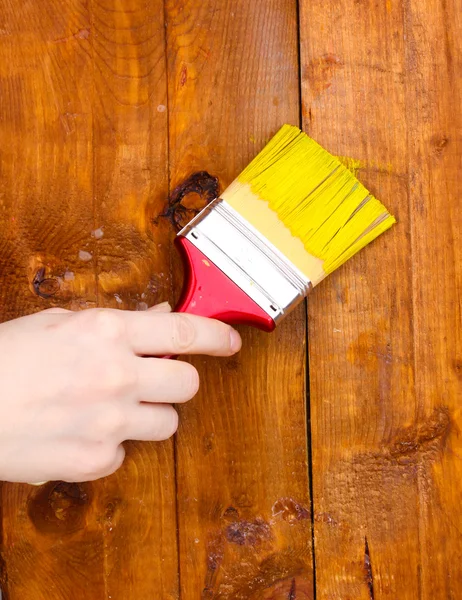 Окраска деревянного забора желтой краской — стоковое фото