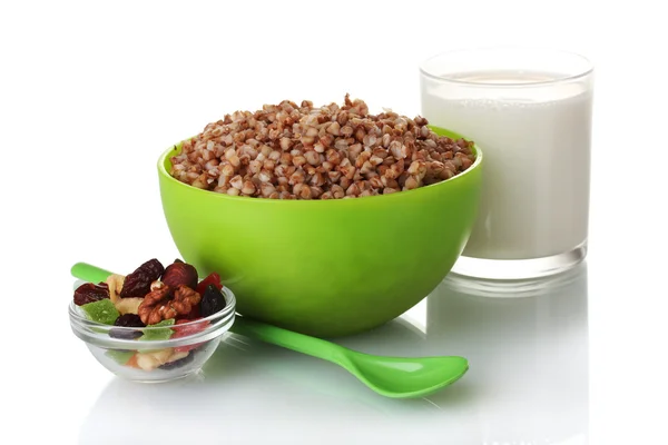 Boiled buckwheat in a green bowl a glass of milk isolated on white — Stock Photo, Image