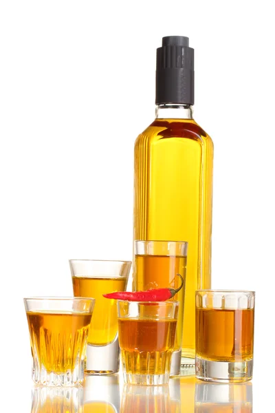 Botella y vasos de vodka pimienta y chile rojo aislado en blanco — Foto de Stock