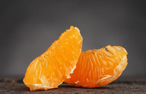 Dos dientes maduros de mandarina sobre mesa de madera sobre fondo gris —  Fotos de Stock