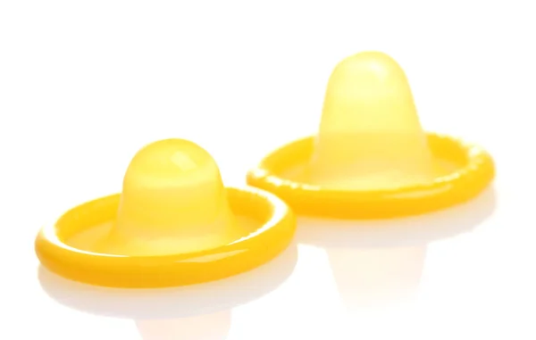 Dvě žluté kondomy izolovaných na bílém — Stock fotografie
