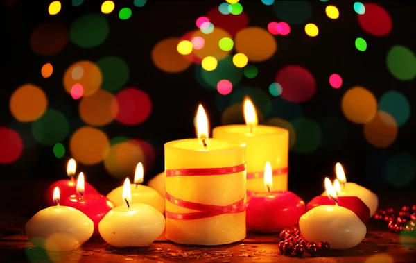Hermosas velas sobre mesa de madera sobre fondo brillante — Foto de Stock