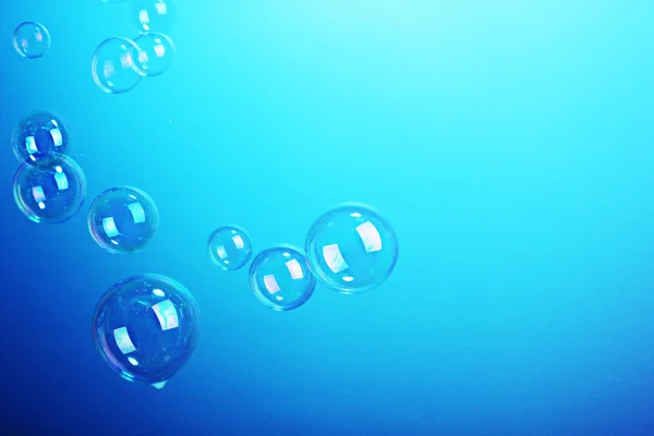 Mýdlové bubliny na modrém pozadí — Stock fotografie