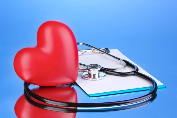 Lékařský fonendoskop s schránky a srdcem na modrém pozadí — Stock fotografie