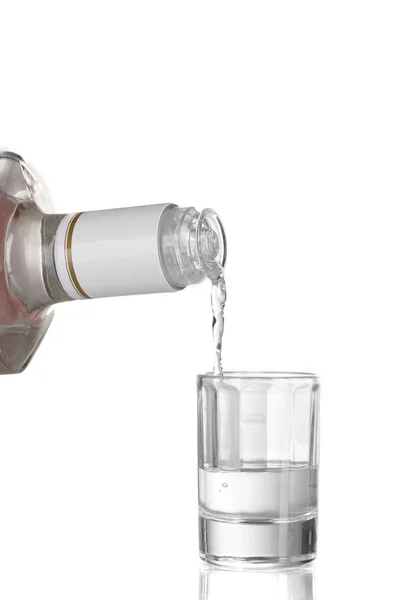 Vodka derramado em um copo isolado em branco — Fotografia de Stock