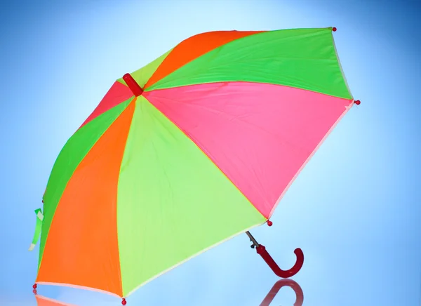 Mehrfarbiger Regenschirm auf blauem Hintergrund — Stockfoto