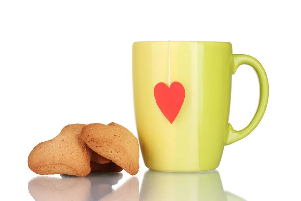 Green cup with tea bag and heart-shaped cookies isolated on white — Stock Photo, Image